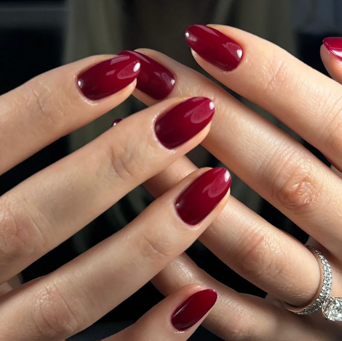 Uñas almendradas color burgundy con acabado brillante.